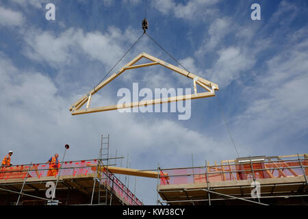 Crane lifting a roof A frame on a new housing estate, Grantham. Lincs, England, UK Stock Photo