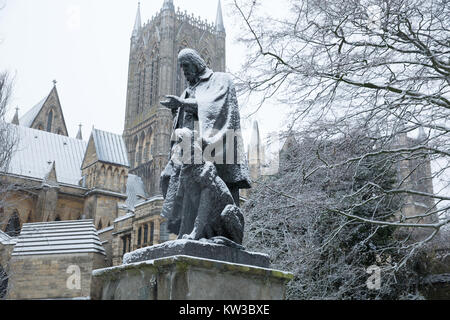 The statue of Tennyson and his dog in Lincoln Cathedral grounds covered by snow Stock Photo