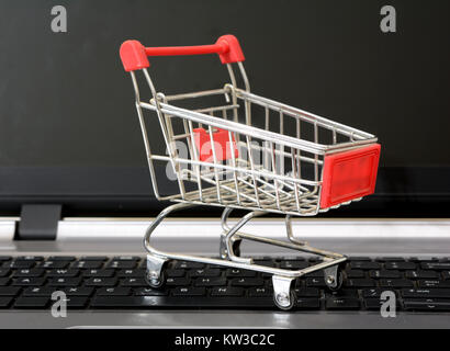 Empty Shopping Cart on Laptop Keyboard - Online concept. Stock Photo