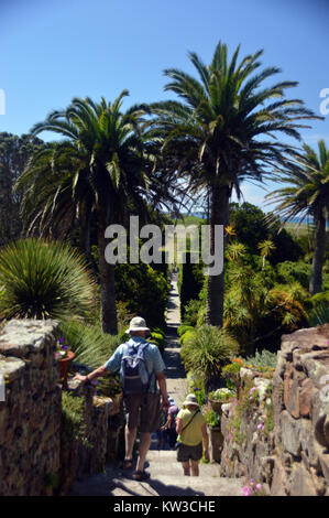 People on the Lighthouse Walk Leading to the Sculpture of the Three Tresco Children Playing in Abbey Gardens, Tresco, Isles of Scilly, Cornwall, UK Stock Photo