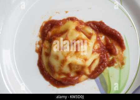 italian kind of dumpling pasta called raviolo and seasoned with tomato sauce Stock Photo