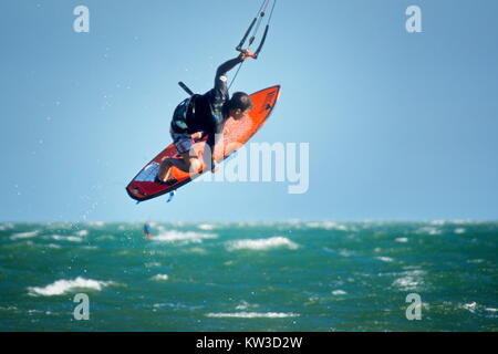 surf kiteboarder kitesurfing and jumping on the sea waves Stock Photo