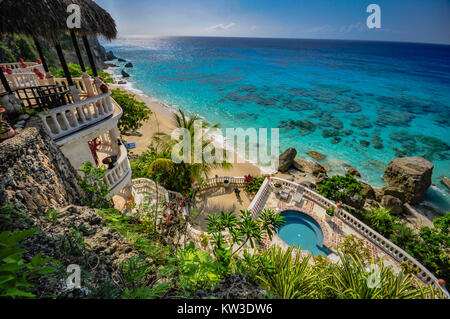 Stunning aerial ocean view of balconies, round pool, and clear ocean at a Caribbean resort. Stock Photo