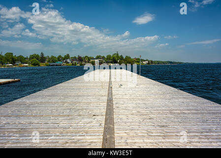 Seagulls on a wooden pier under blue skies with fluffy white clouds Stock Photo