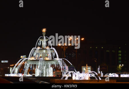 BUCHAREST, ROMANIA - 6 DECEMBER 2017: The fountain at Unirii exchanges jets of water for Christmas lights. Stock Photo