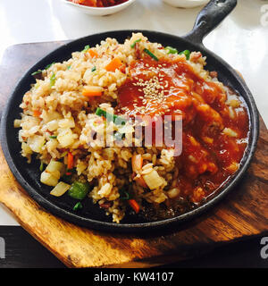 Bokkeum bap is a Korean dish consisting of fried rice, often made with vegetables, meats, or seafood, and seasoned with soy sauce or gochujang. Stock Photo
