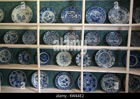 The collection of blue and white ceramic plates from China, Japan, and the Netherlands is displayed at Kelmscott Manor in Oxfordshire, England. These historical pieces showcase the intricate artistry and cultural influences of the respective regions, offering insight into the global exchange of ceramics across time periods. Stock Photo
