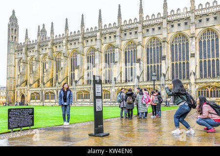 Chinese tourists in the Front Court with the chapel behind them on a rainy day at King's college, university of Cambridge, England. Stock Photo