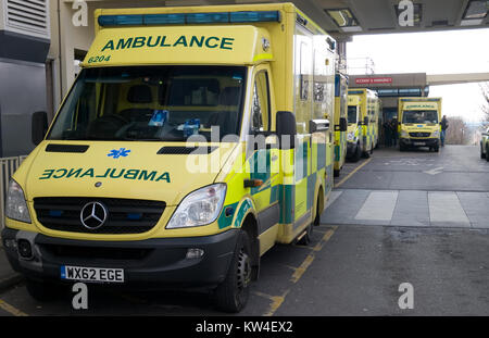 Line of ambulances waiting outside Accident and Emergency department of NHS hospital Stock Photo