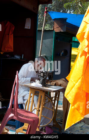 India. Bihar. Bodhgaya, the town where the Buddha sat under a sacred fig tree (bhodi tree) and received enlightenment. Tailor at work. Stock Photo