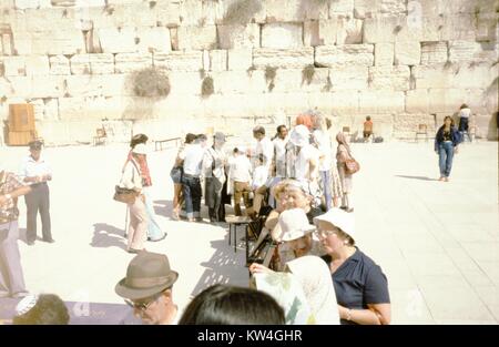 At the Western Wall (Kotel) in Jerusalem, Israel, men and women gather at the fence separating the female portion of the wall from the portion designated for male worshipers, 1975. Until 2016, the Western Wall was divided into sections according to gender, Israel. Stock Photo