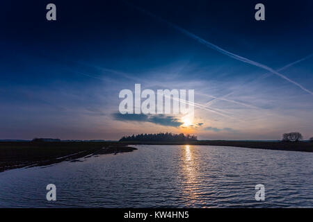 Cold blue evening sunset over the surface of water Stock Photo