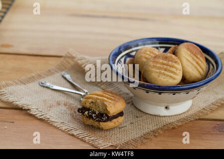 Chocolate filled melting moments on wooden table Stock Photo