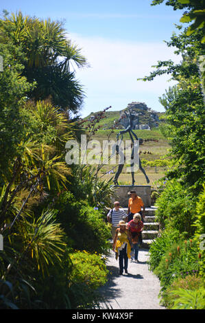 Four People on the Lighthouse Walk from the Sculpture of the Three Tresco Children Playing in Abbey Gardens, Tresco, Isles of Scilly, Cornwall, UK Stock Photo