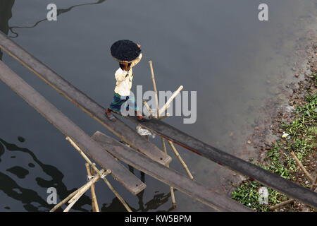 Bangladeshi workers unload coal from a ship in Dhaka. Stock Photo
