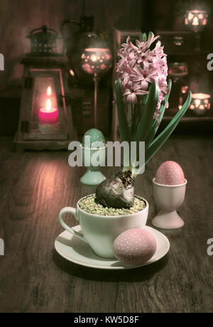 Delicate pink hyacinth on vintage kitchen with candles and Easter eggs, This image is toned Stock Photo