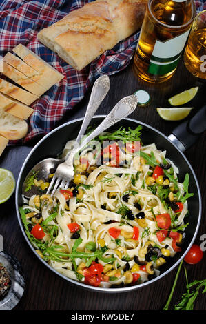 Pasta with crushed olives and cherry tomatoes, arugula. Vertical shot. Stock Photo