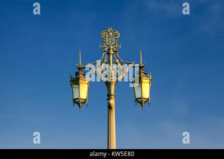 The evening sun catches an historic, ornate, cast iron lamp-standard on Madeira Drive, Brighton. One of 41 installed in 1893 along the seafront. Stock Photo