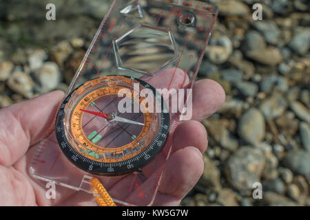 Orienteering compass in hand pointing east. For business direction, navigation, moral compass, getting your bearings concept, orienteering. Stock Photo
