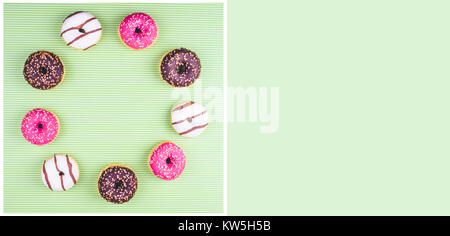 Donut covered with icing, top view on trendy green background. Flat lay style. Stock Photo