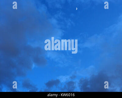 Abstract blue with overflow tonalities background of morning sky with transparent silhouettes of grey clouds. Stock Photo