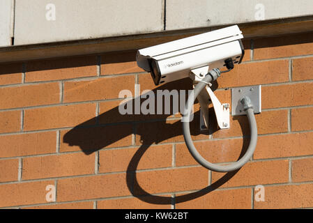 A surveillance camera on a brick wall of a store in Gloversville, NY USA Stock Photo