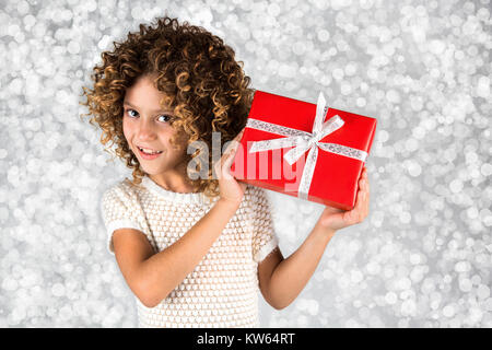 Smiling girl holds gift bow on a sparkling white background Stock Photo