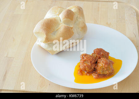 three meatballs on a white dish, with tomato sauce and a fresh rosetta typical italian bread Stock Photo