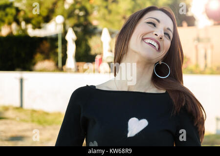 Portrait of a woman laughing spontaneously, cheerful, outdoors. Stock Photo