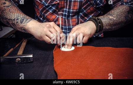 Artist working with leather creating a new leather product Stock Photo