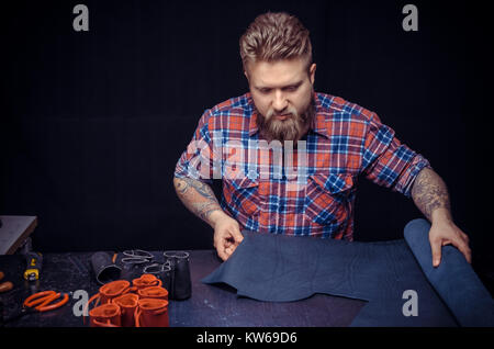 Artisan of leather working as artisan at his leather shop Stock Photo