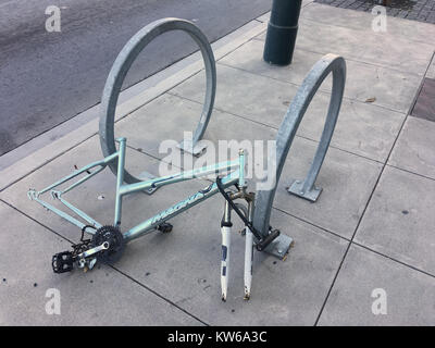 Stripped bicycle frame locked to bike stand on street in San Francisco California Stock Photo