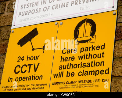 Security sign on a wall warning of clamping if parking is unauthorised Stock Photo