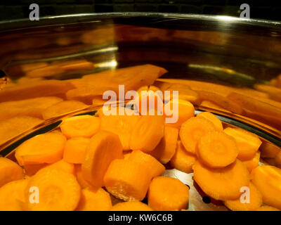 Carrots lying reflected in a stainless,steel steamer pan Stock Photo