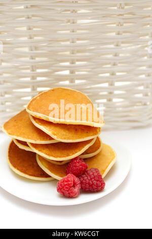 Small pancakes topped with berries isolated on white. Food background Stock Photo