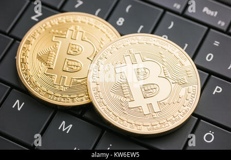 Digital currency physical golden bitcoin coins on black computer keyboard Stock Photo