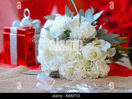 All white bridal bouquet perfect for a winter or holiday wedding with roses, carnation, eucalyptus and highlighted with pearls. Stock Photo
