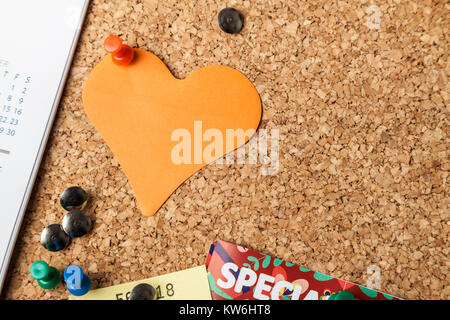 Blank Heart shaped Note on cork notice board with red pin Stock Photo