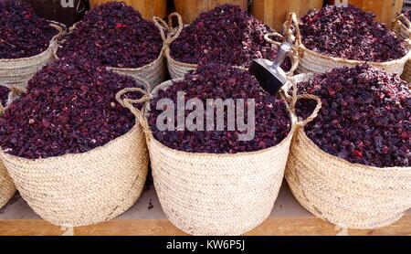Close up of 6 handmade baskets full of crimson dried hibiscus flowers 'karkade' on market stall in Cairo, Egypt. A popular infusion at celebrations Stock Photo
