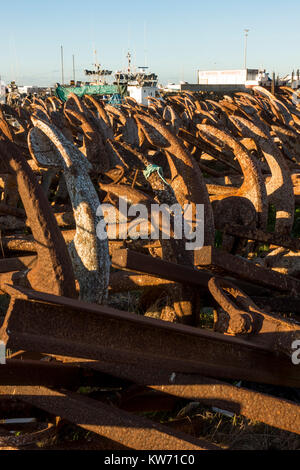 Rusty Anchors, used for Tuna fishing, Out of season stacked on dry land in port of Barbate, Costa de  la luz, Andalusia, Spain. Stock Photo