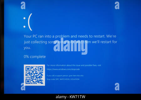 A laptop screen showing 'Your PC ran into a problem and needs to restart.' Theme - computer problems, crash, blue screen, error, broken Stock Photo