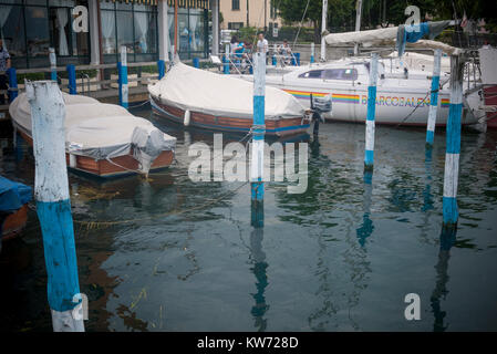 Boats moored on the jetty by Lake Iseo, Italy Stock Photo