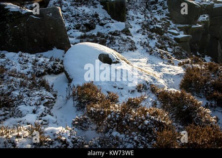 Snow covered abandoned millstone on Derwent edge in the Peak District, Derbyshire, England. Stock Photo