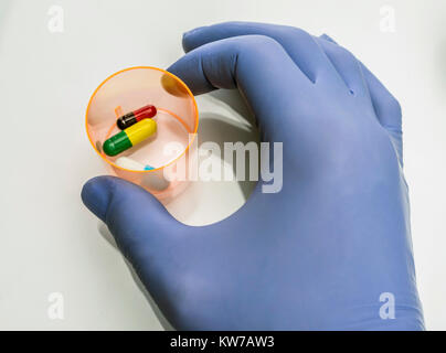 Doctor holds glass with medication for palliative care in hospital, conceptual image Stock Photo