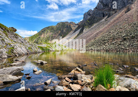 Little shallow lake with clear clear water in Siberian mountains. High mountain tundra. Eastern Siberia. Russia Stock Photo