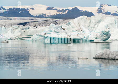 Jokulsarlon glacier lagoon bay with blue icebergs floating on still water with reflections, south Iceland during summer time. Stock Photo
