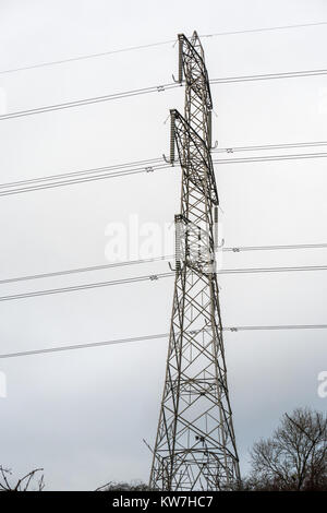 High lattice electricity pylon with coils and cables against cloudy sky,  Scotland, UK Stock Photo