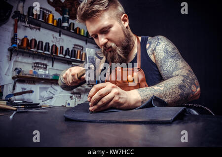 Close up of a shoemaker man working with leather using crafting tools Stock Photo