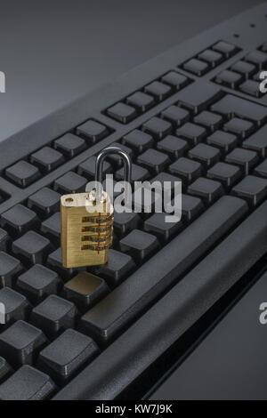 Combination padlock on blank black Qwerty keyboard - as visual metaphor for concept of secure data, email security, data protection - with copy space. Stock Photo