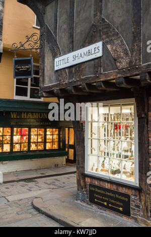 Road junction on quaint historic Shambles, York with 2 jewellers shops on either side of narrow street with bright window displays - England, UK. Stock Photo